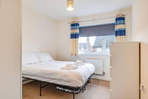 a bed in a room with a large window at Cosy 2 Bedroom Home in Wigan in Wigan