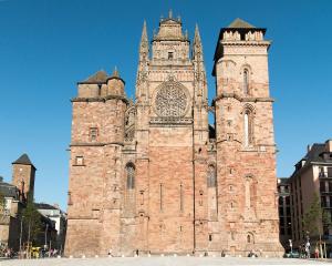 a large brick building with a clock tower at Le Planard in Rodez +6 photos