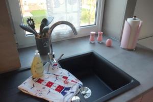 a kitchen counter with a sink with a kitchen appliance at Ferienwohnung Sternenkieker in Krummhörn