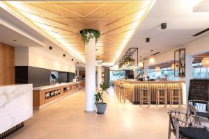 a restaurant with a bar and a dining area at Malena Hotel & Suites - Adults Only by Omilos Hotels in Amoudara Herakliou