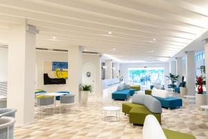 una hall con sedie e tavoli blu e verdi di HOTIDAY Hotel Sorrento a Sorrento