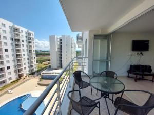 a balcony with a glass table and chairs in a apartment at Aqualina Orange Apartamento Piso 6 Vista a Piscina 3 Habitaciones in Girardot