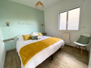 - une chambre avec un lit doté d'une couverture jaune dans l'établissement L'Atelier des Rêves, à Veyrier-du-Lac