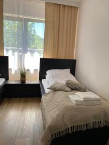 1 dormitorio con cama y ventana grande en Apartamenty nad Zalewem, en Serock