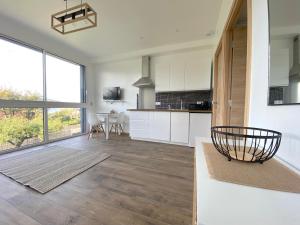 a kitchen with white cabinets and a large window at L'Atelier des Rêves in Veyrier-du-Lac