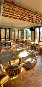 uma sala de jantar com mesas, cadeiras e janelas em Ludrong Hotel em Thimphu