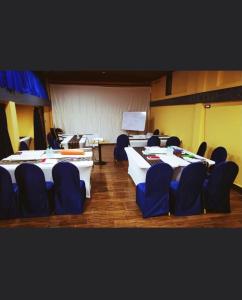 a conference room with tables and chairs and a screen at Ludrong Hotel in Thimphu