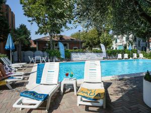 un grupo de tumbonas junto a la piscina en Dasamo Hotel - Dada Hotels en Rímini