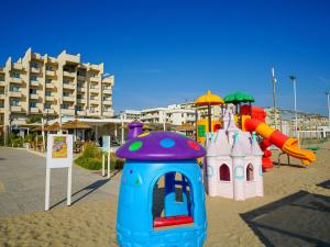 um parque infantil na areia perto de um hotel em Dasamo Hotel - Dada Hotels em Rimini