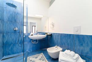 サレルノにあるIl Papavero Residence Arbostellaの青と白のバスルーム(洗面台、トイレ付)