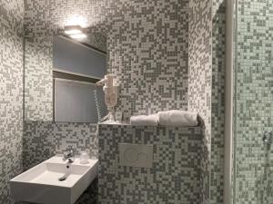 een badkamer met een wastafel en een spiegel bij 3 Paardekens - City Centre Hotel in Mechelen