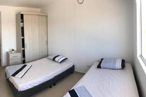 2 camas en una habitación pequeña con ermottermottermott en Apartamento vacacional en Girardot Cundinamarca - AQUALINA ORANGE piso 3 vista a la piscina, en Bogotá