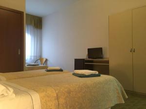 ein Hotelzimmer mit 2 Betten und einem TV in der Unterkunft Hotel Centrale in Este