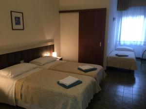 ein Hotelzimmer mit 2 Betten und Handtüchern darauf in der Unterkunft Hotel Centrale in Este