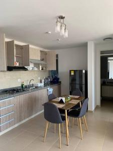 una cocina con mesa de madera y sillas. en Apartamento vacacional en Girardot Cundinamarca - AQUALINA ORANGE piso 3 vista a la piscina, en Bogotá