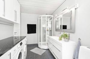 a white bathroom with a sink and a mirror at Sjarmerende familievennlig hus med 2 soverom in Kristiansand