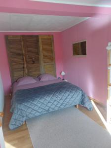 1 dormitorio con 1 cama grande y paredes de color rosa en Chez Nadine en Ranspach