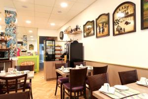 une salle à manger avec des tables et des chaises dans un restaurant dans l'établissement Hôtel Gloria, à Grenoble