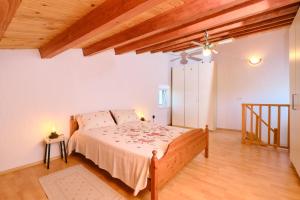 a bedroom with a bed and a wooden ceiling at Domus Olivae in Nerezine