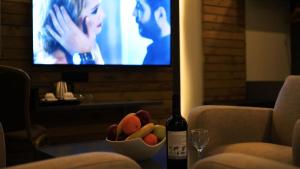 uma garrafa de vinho e uma taça de fruta numa mesa em Aitch Boutique Hotel - an LIH Hotel em Madaba