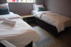 two beds in a small room with a window at Sable Holiday Home in Hazyview