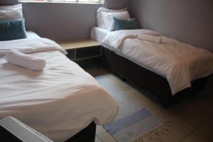 a room with two beds and a table and a window at Sable Holiday Home in Hazyview