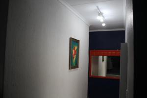 a room with a mirror and a painting on a wall at Sable Holiday Home in Hazyview