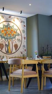 une salle à manger avec des tables et des chaises en bois et un tableau dans l'établissement Aitch Boutique Hotel - an LIH Hotel, à Madaba