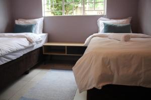 a bedroom with two beds and a window at Sable Holiday Home in Hazyview