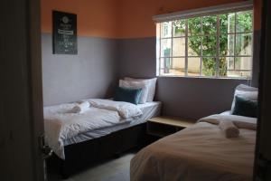a small room with two beds and a window at Sable Holiday Home in Hazyview