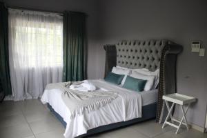 a bedroom with a bed with a metal frame and a window at Sable Holiday Home in Hazyview
