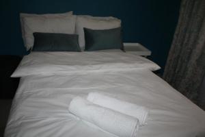 a white bed with two towels on top of it at Sable Holiday Home in Hazyview
