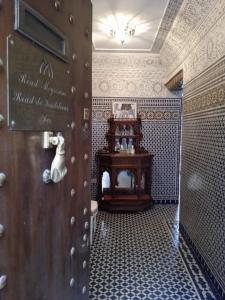 a bathroom with a wooden door and a table at Riad Meyssane Fès in Fez