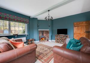 a living room with a couch and a fireplace at CowPasture Cottage in Felixstowe