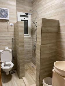 a bathroom with a toilet and a glass shower at La hacienda Luxurious chalet with sea view garden 805 in Ras Sedr