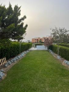 La hacienda Luxurious chalet with sea view garden 805 في رأس سدر: ساحة كبيرة مع مقعد في الحديقة