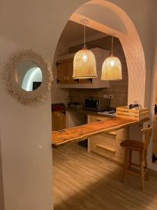 a kitchen with a wooden table and two lights at La hacienda Luxurious chalet with sea view garden 805 in Ras Sedr