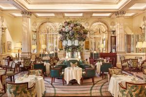 a dining room with tables and chairs and a flower arrangement at Claridge's in London