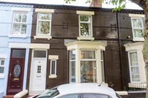 a white car parked in front of a brick house at Air Host and Stay - Keith House, 3 bedroom sleeps 6 free parking in Liverpool