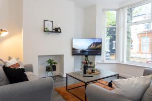 a living room with a couch and a tv on a wall at Air Host and Stay - Keith House, 3 bedroom sleeps 6 free parking in Liverpool