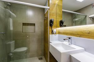 a bathroom with a sink and a toilet and a mirror at Apart Hotel Centro de Brasília in Brasilia +10 photos