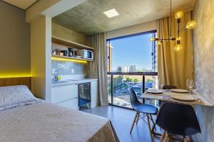 1 dormitorio con 1 cama y 1 mesa con sillas en Apart Hotel Centro de Brasília, en Brasilia