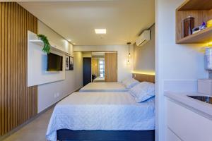 a bedroom with two beds and a sink at Apart Hotel Centro de Brasília in Brasilia