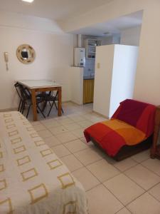a room with a bed and a table and a kitchen at Departamento Ricchieri 743 in Rosario
