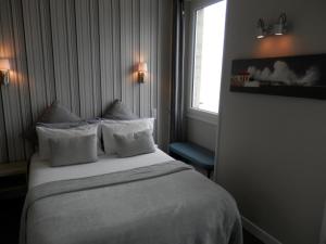 シブールにあるオテル　ラ　カラベルのベッドと窓が備わるホテルルーム