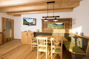 uma cozinha com uma mesa de madeira e cadeiras em Erbhof Fritzing em Ebbs