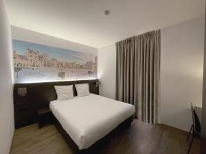 a bedroom with a white bed with a painting on the wall at 3 Paardekens - City Centre Hotel in Mechelen