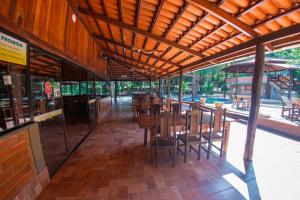 a restaurant with wooden tables and chairs in a building at IPÊ Florido Parque Hotel in Paracatu