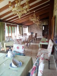 een eetkamer met tafels en stoelen en een kroonluchter bij Casa Almoina in Viveiro