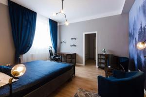 a bedroom with a blue bed and a table and chairs at Joy City Stay Piatra Craiului 8 in Timişoara